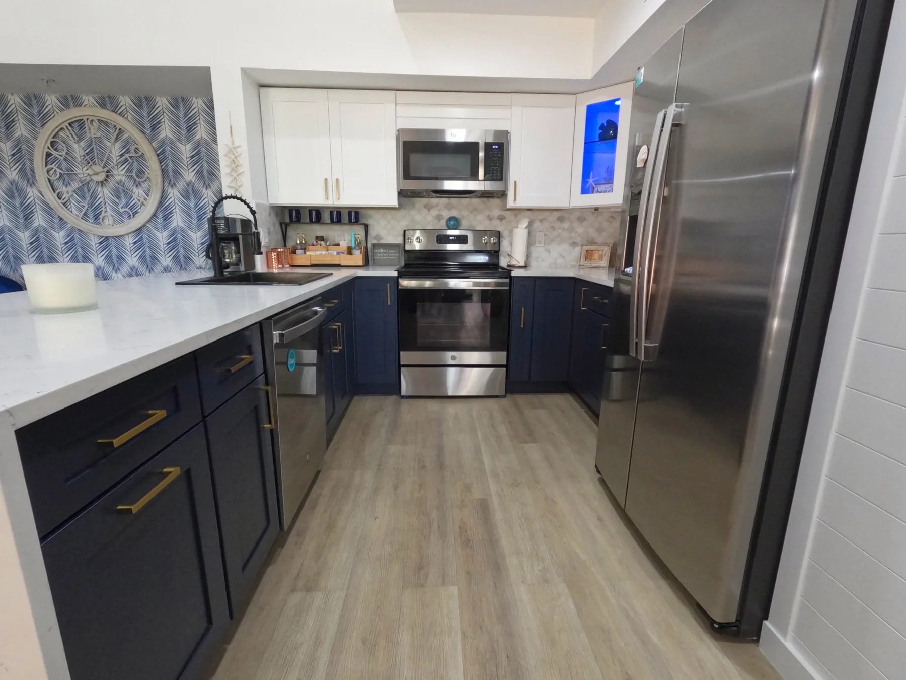 Fully equipped kitchen with white cabinets and blue accents at Royal Palm Retreat, stocked for a monthly stay in Naples